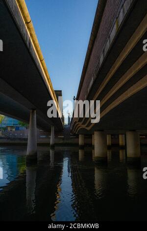 Modern bridge across water shot against a blue sky. Stock Photo