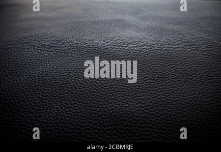 Close-up of detailed dark gray or black faux leather surface. Shallow depth of field, focus on front. High resolution full frame textured background. Stock Photo