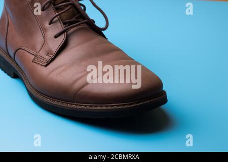Brown leather man shoe on blue background with copy space Stock Photo