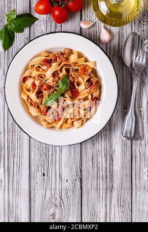 Traditional italian pasta bolognese on a white plate on a wooden background, top view. Stock Photo