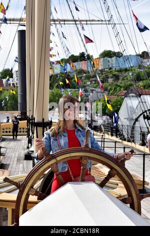 Tourist hold the stern steering wheel of Isambard Kingdom Brunel's SS Great Britain in Great Western Dockyard in Bristol Stock Photo