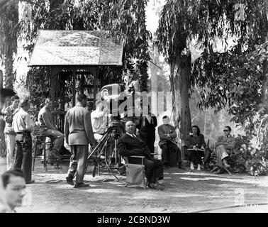 ALFRED HITCHCOCK and Film Crew including Production Assistant BARBARA KEON on set location candid during filming of NOTORIOUS ! 1946 director ALFRED HITCHCOCK writer BEN HECHT gowns EDITH HEAD Vanguard Films / RKO Radio Pictures Stock Photo