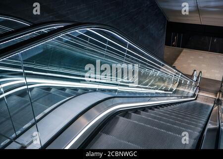 Looking down futuristic escalator moving stairs in modern offices Stock Photo