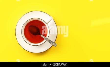 Flat lay photo, white porcelain cup of hot tea with silver spoon, on yellow board, space for text right Stock Photo