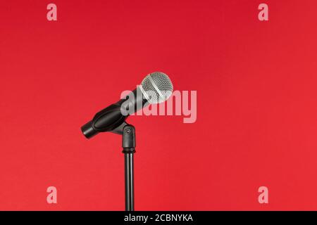 Microphone and stand, isolated against a bright red background, with copy space Stock Photo