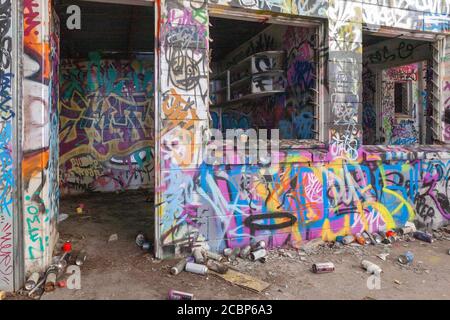 Interior view of an old and abandoned building decorated chaotically with different graffiti arts Stock Photo
