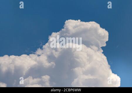 Huge cumulonimbus high in the deep blue sky Stock Photo