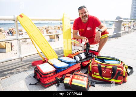 14 August 2020, Schleswig-Holstein, Travemünde: Hans-Jörg Andonovic-Wagner, watchman of the DLRG rescue station Travemünde, shows a part of the medical and rescue equipment of his team during a photo session. This summer, the lifeguards of the German Life Rescue Society (DLRG) at the Baltic Sea are in a dilemma. Distance regulations due to the corona pandemic made rescue operations more difficult, but there have been no problems with rescue operations despite the crowded beaches of the past few days. Photo: Christian Charisius/dpa Stock Photo