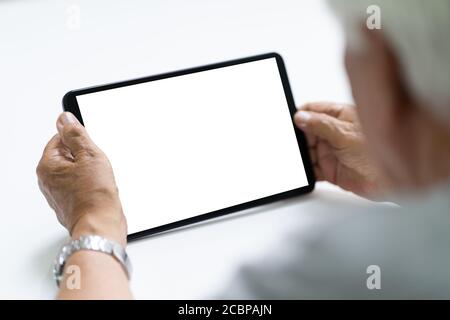 Elderly Senior Hand Using Tablet Computer With Empty Screen Stock Photo