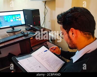 DISTRICT KATNI, INDIA - MARCH 18, 2020: An indian office male executive working at office infront of desk top computer on table. Stock Photo