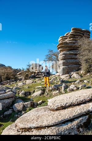 Young man standing on rocks, limestone rock formations, El Torcal Nature Reserve, Torcal de Antequera, Malaga Province, Andalusia, Spain Stock Photo