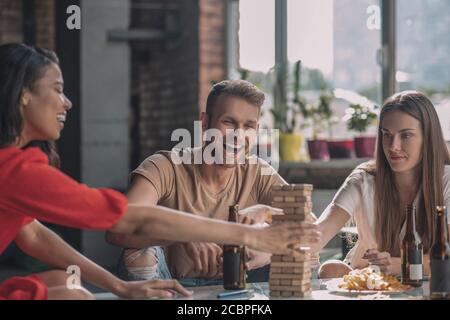 Friends having fun while playing Jenga at the party Stock Photo