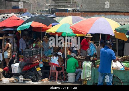 Cartagena Columbia busy outdoor market shoppers fish vegetables. 5095. Historical poor neighborhood outdoor market. Raw fresh meat, beef, pork and fish prepared in hot unsanitary conditions. Dirty, smelly environment with rotten food. Local restaurants and shopping. Stock Photo