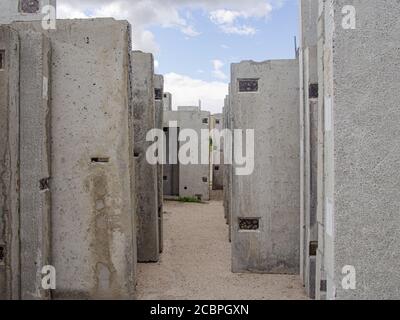 Building materials and reconstruction. Reinforced concrete wall panels, stacked vertically in a storage area. Side view Stock Photo
