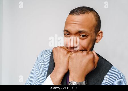 Shocked horrified african american man covering mouth with hands feel scared over grey background Stock Photo