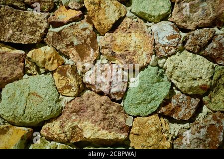 Multi-coloured stones forming a wall. Soft natural colours of the stones. Stock Photo