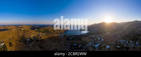 Kea Tzia island, Cyclades, Greece. Panorama of Otzias bay at sunrise. Sun coming up at dawn behind the hills, calm water, aerial view from drone Stock Photo