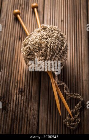 Ball of wool with knitting needles on wooden background. Concept of handcraft. Stock Photo