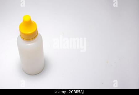 WHITE BOTTLE WITH YELLOW CAP ON A WHITE BACKGROUND. Stock Photo