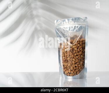 blank standing pouch mockup with nuts on transparent window Stock Photo