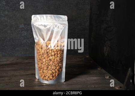 peanut snack on a blank standing pouch mockup with transparent window Stock Photo