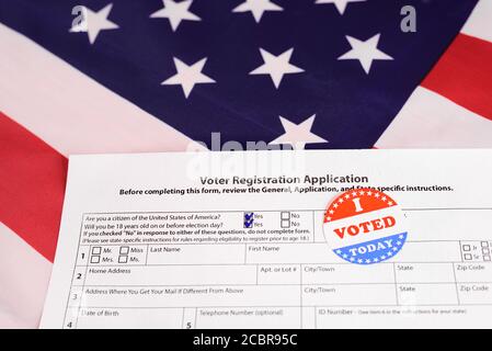 American citizens fill out the form to apply in the voting, on patriotic background of American flag. Stock Photo