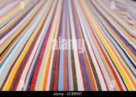 Parallel colored lines on a fabric, blurred background out of focus at the end. Stock Photo