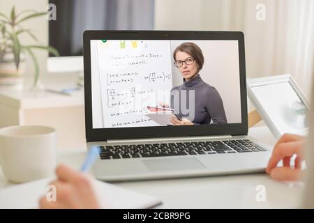 The teacher leads an online lesson for schoolchildren or students. Female professor communicates via video conference. E-learning. Distance learning c Stock Photo