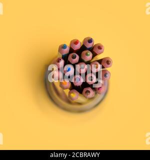 Сolored pencils in a jar on a yellow background Stock Photo