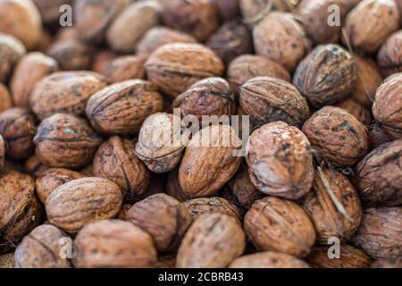 Walnuts in their shells for sale on a market stall Stock Photo
