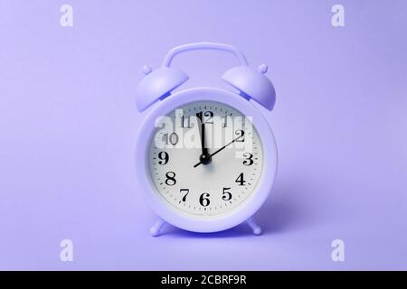 Top view of classic alarm clock on purple background. Time concept Stock Photo