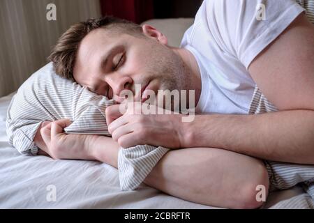 Young man sleeping in bed, at home. Stock Photo