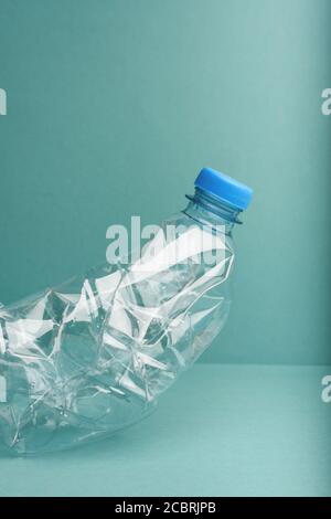 Used crushed plastic bottles on blue background. Stock Photo