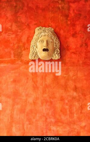 Stone face of woman against a bright orange wall. Ancient Roman head in museum Glyptotek in Copenhagen, Denmark Stock Photo