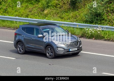 2015 grey Hyundai Santa FE Premium SE CRDI; Vehicular traffic moving vehicles, cars driving vehicle on UK roads, motors, motoring on the M6 motorway highway network. Stock Photo