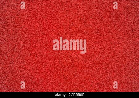 Red wall of the building. Rough plaster surface. Abstract background. Stock Photo