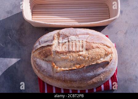 Artisan bread baking basket with a sourdough loaf of bread. Stock Photo