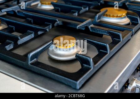 Gas stove and embedded electric oven at brand new modern wooden kitchen. Close up photo Stock Photo