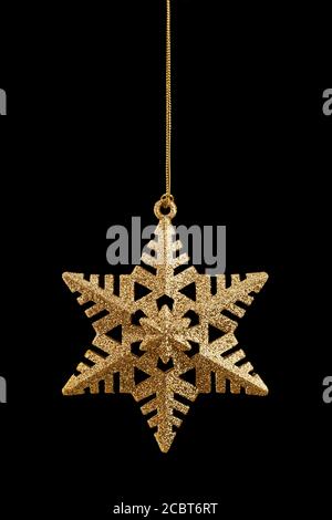 Golden Christmas star isolated on black background. Stock Photo