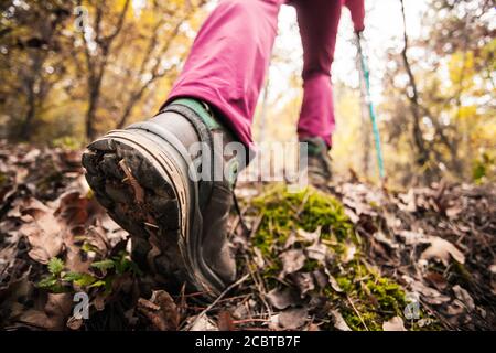Hiking girl in a mountain. Low angle view of generic sports shoe and legs in a forest. Healthy fitness lifestyle outdoors. Stock Photo
