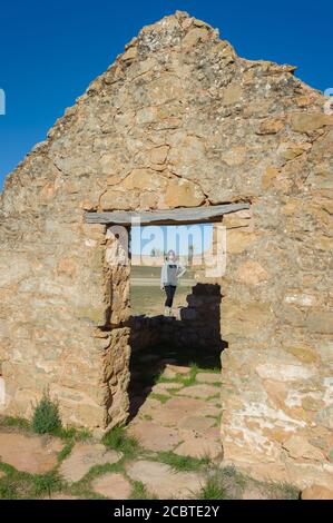 Female model standing in the doorway of old ruins at Kanyaka historical homestead in the Flinders Ranges of South Australia. Stock Photo