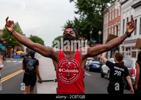 Washington, DC, USA. 15th Aug, 2020. Pictured: a protester at the Defund the Police March holds his middle fingers in the air, physically interpreting the chant by the crowd. Credit: Allison C Bailey/Alamy Credit: Allison Bailey/Alamy Live News Stock Photo