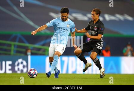 Lisbon, Portugal. 15th Aug, 2020. Ilkay Gundogan (L) of Manchester City is challenged by Maxence Caqueret of Olympique Lyon during the UEFA Champions League Quarter Final match between Manchester City and Olympique Lyon in Lisbon, Portugal, Aug. 15, 2020. Credit: Julian Finney/UEFA/Handout via Xinhua/Alamy Live News Stock Photo