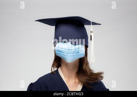 Graduation girl portrait, vearing medical mask. Self isolation, quarantine, virtual graduation concept Stock Photo