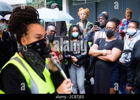 London, UK. 15th Aug, 2020. A woman speaks as people listen outside Lewisham town hall during the commemoration of the Battle of Lewisham.Counter-protesters gathered close to the assembly point of white-nationalist group in 1977 with the intention of blocking its path resulting in violent clashes. Credit: SOPA Images Limited/Alamy Live News Stock Photo