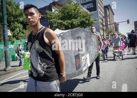 Vancouver, Canada. 15th Aug, 2020. Protestors carry a wooden coffin while participating in a memorial march in Vancouver, British Columbia, Canada, Aug 15, 2020. Dozens of protestors took down the street to commemorate their friends and family members who died from overdose during the COVID-19 pandemic in the past months. Credit: Liang Sen/Xinhua/Alamy Live News Stock Photo