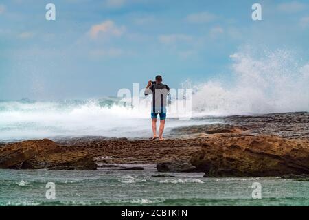 Traveler photographs huge tsunami waves on a smartphone, a dangerous hobby Stock Photo