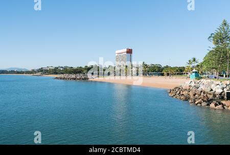 The tropical beach and Strand park with one of the few high rises built on The Strand, Townsville, North Queensland, Australia Stock Photo