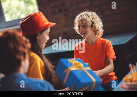 Cute blonde boy receiving gifts from friends Stock Photo