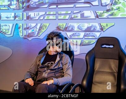 man in VR goggles sitting on a chair enjoying virtual reality demonstration at TSMC museum Stock Photo